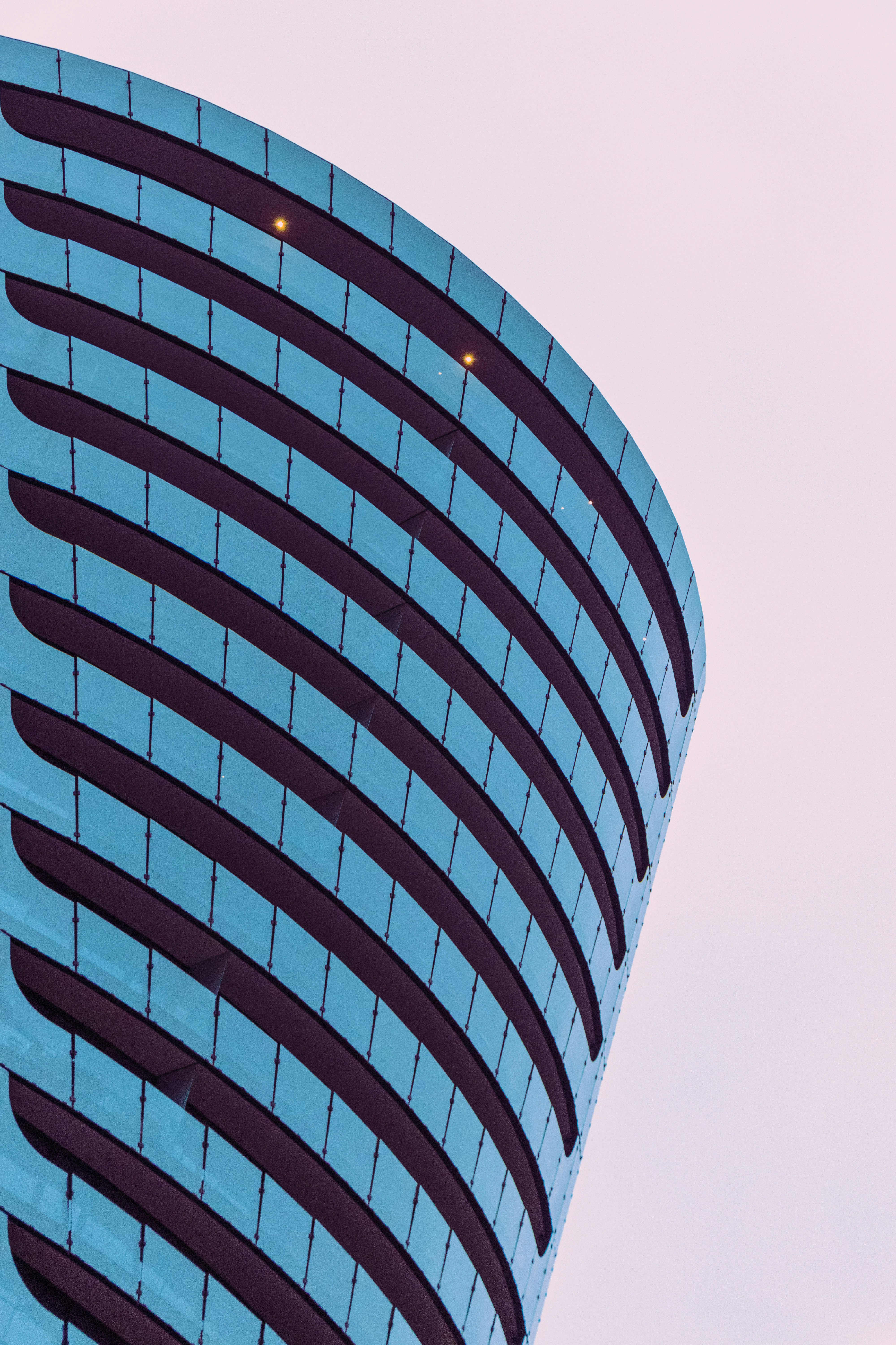 blue and white glass walled high rise building